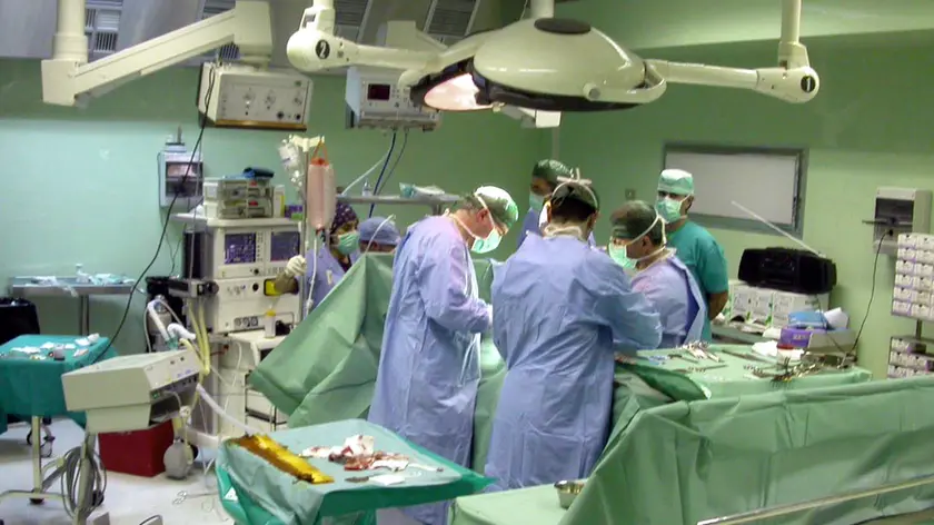 20070220 - ROMA - CRO - SANITA': IMPIANTATI IN TRE PAZIENTI ORGANI DI SIEROPOSITIVO. Una equipe medica al lavoro in sala operatoria, in una immagine del 02 marzo 2004. Gli organi espiantati da una donna ..di 41 anni, sieropositiva, sono stati impiantati su tre pazienti toscani. Un errore umano, all'origine dell'incidente giudicato dai sanitari ''un evento estremamente grave'', avvenuto all'ospedale fiorentino di Careggi. A rendere noto il fatto, a poche ore dall'emergere dell'errore, sono stati il direttore dell'Organizzazione toscana trapianti, Franco Filipponi, e il direttore sanitario dell'Azienda Ospedaliero Universitaria di Careggi Mauro Marabini...ANSA/ARCHIVIO - MARIO ROSAS - DRN