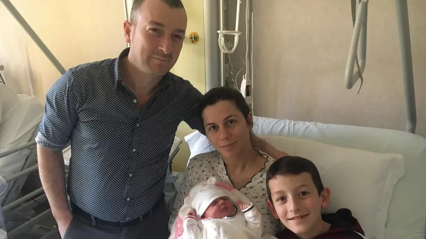 La piccola Leonora tra le braccia della sua mamma e attorniata dal papà e dal fratello