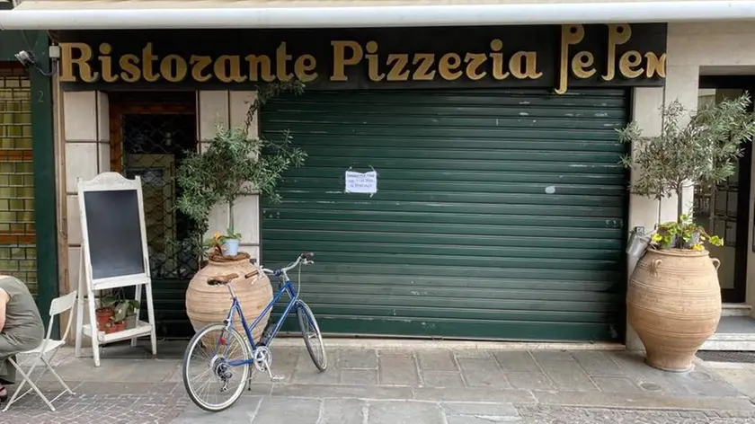 Serrande abbassate del ristorante pizzeria Pe Pen in piazza Cavour a Padova