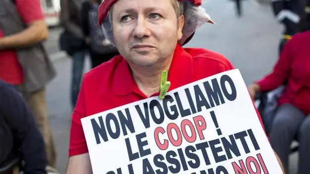 Raffaele Pennacchio, 55 anni, del direttivo del Comitato 16 novembre onlus, protesta davanti al ministero delle Finanze per chiedere condizioni migliori riguardo l'assistenza familiare a domicilio e un incontro con il ministro, Roma, 22 ottobre 2013. Sul cartello: 'Non vogliamo le Coop. Gli assistenti li scegliamo noi'..ANSA/ GUIDO MONTANI