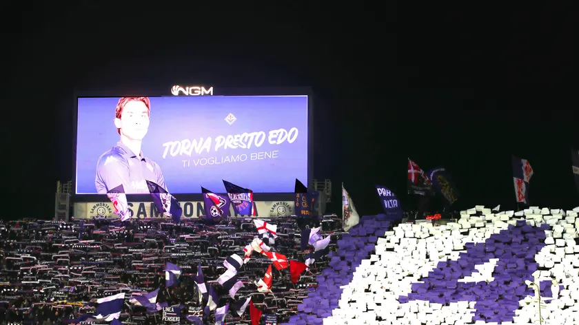 Supporters cheer for their team Fiorentina during the Italian Coppa Italia cup soccer match between ACF Fiorentina vs Empoli FC at Artemio Franchi Stadium in Florence, Italy, 4 December 2024. On the board is the image of the Fiorentina midfielder Edoardo Bove who collapsed at 17' Fiorentina-Inter on Sunday evening and is now hospitalized. ANSA / CLAUDIO GIOVANNINI