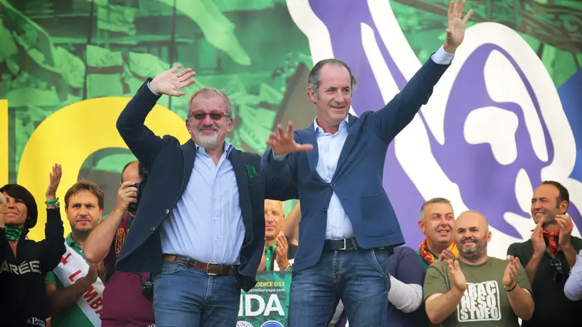 I governatori di Lombardia e Veneto, Roberto Maroni e Luca Zaia, salutano dal palco i militanti al raduno leghista di Pontida, che quest'anno si celebra a settembre nel ventennale della dichiarazione di indipendenza della 'Padania', 18 settembre 2016. ANSA / GIANPAOLO MAGNI . .