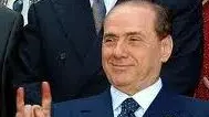Silvio Berlusconi in un suo noto gesto A destra poco più che ragazzo