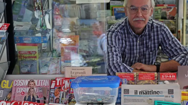 Daniele Morello nella sua edicola di piazza Capitaniato e la cassettina dove lasciare i soldi (FOTO BIANCHI)