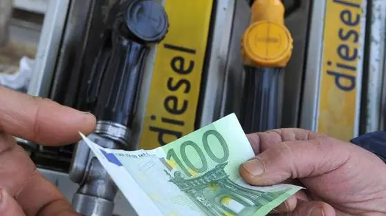Un benzinaio alla pompa di benzina, riceve un biglietto da 100 euro per il pagamento del carburante da un cliente, 12 marzo 2012 a Pisa. ANSA/FRANCO SILVI