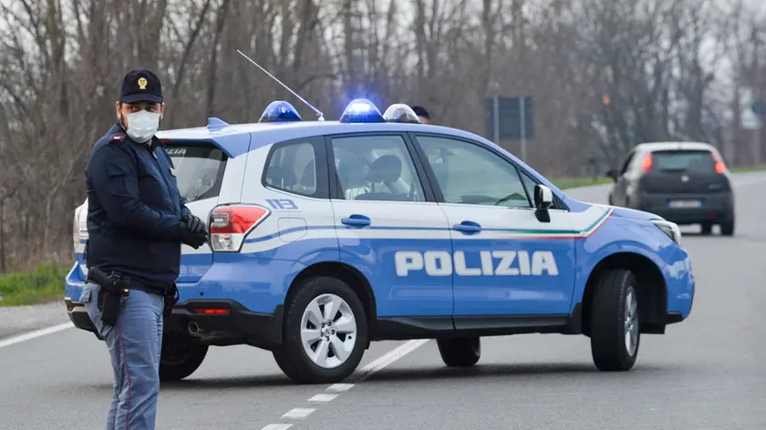 Italian National Police officers stand by as they inform residents at the entrance of the small town of Casalpusterlengo, southeast of Milan, on February 23, 2020, under the shadow of a new coronavirus outbreak, as Italy took drastic containment steps as worldwide fears over the epidemic spiralled. ANSA/ANDREA FASANI
