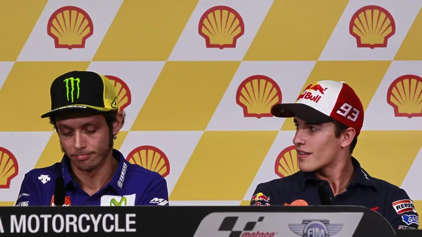 epa04988573 Spanish Moto GP rider Marc Marquez (R) of the Repsol Honda Team looks at Italian MotoGP rider Valentino Rossi (L) of Movistar Yamaha MotoGP during a news conference held at the Sepang International Circuit, Sepang, Malaysia, 22 October 2015, ahead of the Shell Malaysia Motorcycle Grand Prix in Sepang from 23 to 25 October. EPA/FAZRY ISMAIL