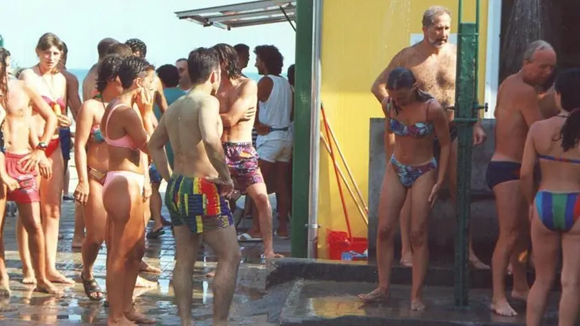Persone in fila per fare la doccia in spiaggia: a Caorle non si potrà più fare dopo le 19