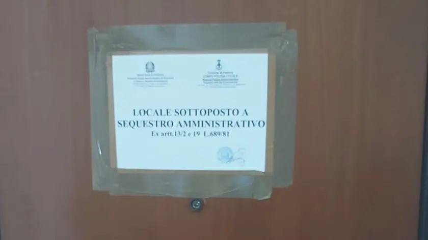 L'avviso di sequestro sulla porta dell'appartamento