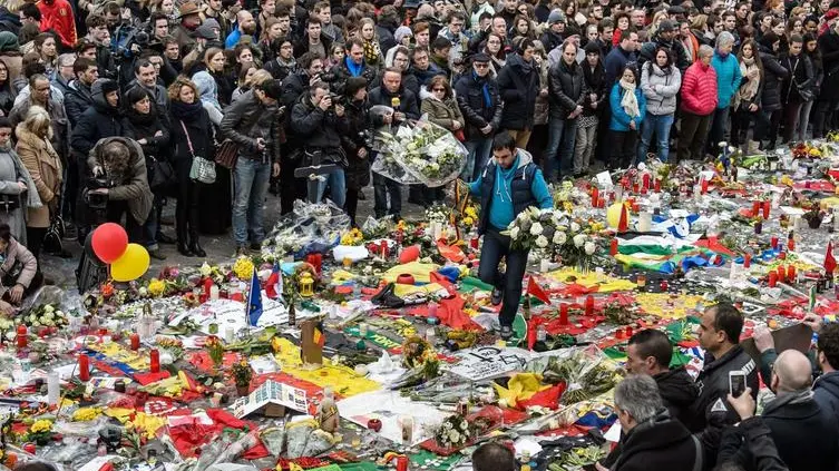 epa05229158 Thousands of people gather and pay tribute to the many people killed and injured in multiple terrorist attacks in Brussels on 22 March, during a minute of silence at Place de la Bourse, Brussels, Belgium, 24 March 2016. Security services are on high alert following two explosions in the departure hall of Zaventem Airport and one at Maelbeek Metro station in Brussels. Many people died and even more were injured in the attacks which Islamic State (IS) has since claimed responsibility for. EPA/CHRISTOPHE PETIT TESSON