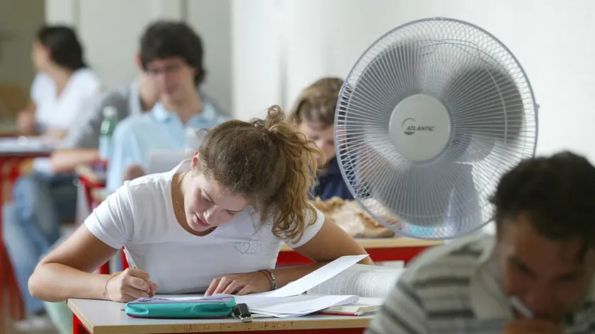 Alcuni studenti mentre svolgono un esame rinfrescati dal ventilatore