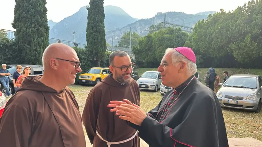 Da sinistra padre Luca Trivellato e un confratello conversano con il vescovo di Trento Lauro Tisi