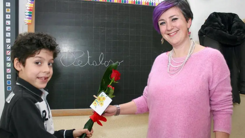 Il bambino Matteo Trovò, 8 anni, alunno delle classe terza delle scuole elementari 'Marchesi di Copparo' inventore del neologismo 'petaloso', con la maestra Margherita Aurora in una foto diffusa dalla 'Nuova Ferrara', 24 Febbraio 2016. ANSA/ ROSSETTI