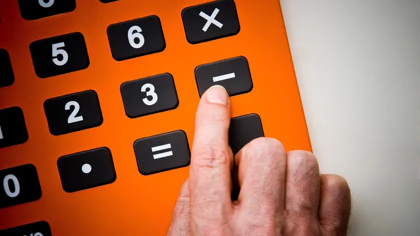Finger pushing calculator buttons.