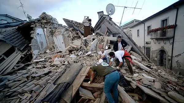 TOPSHOT - Resident search for victims in the rubble after a strong heartquake hit Amatrice on August 24, 2016 Central Italy was struck by a powerful, 6.2-magnitude earthquake in the early hours, which has killed at least three people and devastated dozens of mountain villages. Numerous buildings had collapsed in communities close to the epicenter of the quake near the town of Norcia in the region of Umbria, witnesses told Italian media, with an increase in the death toll highly likely. / AFP PHOTO / FILIPPO MONTEFORTE
