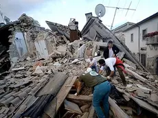 TOPSHOT - Resident search for victims in the rubble after a strong heartquake hit Amatrice on August 24, 2016 Central Italy was struck by a powerful, 6.2-magnitude earthquake in the early hours, which has killed at least three people and devastated dozens of mountain villages. Numerous buildings had collapsed in communities close to the epicenter of the quake near the town of Norcia in the region of Umbria, witnesses told Italian media, with an increase in the death toll highly likely. / AFP PHOTO / FILIPPO MONTEFORTE