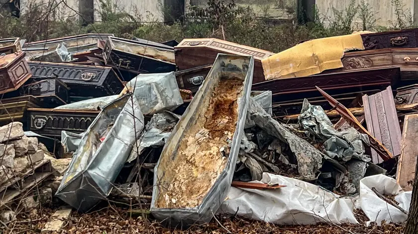 Le vecchie bare abbandonate dietro alle tombe nel cimitero di Monselice