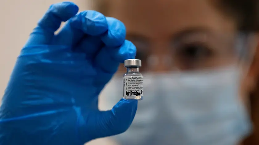 A nurse holds a phial of the Pfizer-BioNTech COVID-19 vaccine at Guy\'s Hospital in London, Tuesday, Dec. 8, 2020. U.K. health authorities rolled out the first doses of a widely tested and independently reviewed COVID-19 vaccine Tuesday, starting a global immunization program that is expected to gain momentum as more serums win approval. (AP Photo/Frank Augstein, Pool)
