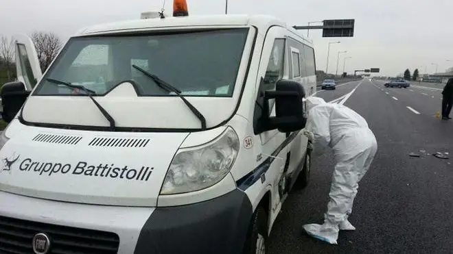 Un agente della scientifica effettua dei rilievi sul furgone portavalori assaltato dai banditi sull'autostrada A9 a Como, 8 aprile 2013. Oltre ai dieci rapinatori che hanno bloccato i due furgoni portavalori, all'assalto devono avere partecipato anche parecchi complici. L'Autolaghi, infatti, è stata letteralmente disseminata di chiodi a tre punte per bloccare o quantomeno rallentare l'arrivo delle forze di polizia. ANSA/GIORGIANA CRISTALLI