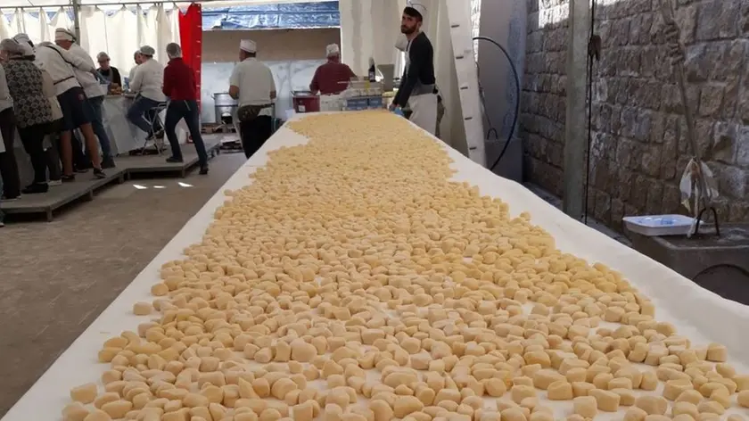 Una lunghissima tavolata piena di gnocchi