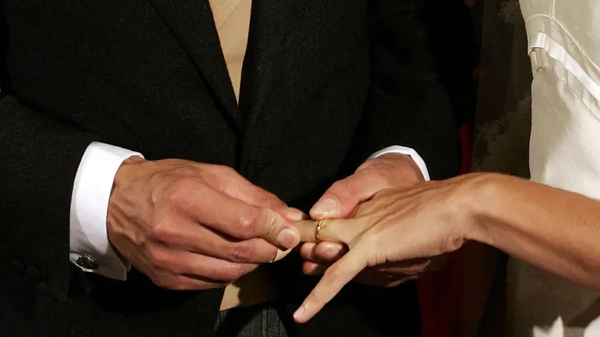 Scambio di fedi nunziali in un'immagine d'archivio. L'Instrumentum laboris, il testo base per il sinodo d'autunno sulla famiglia, a proposito dei "divorziati risposati civilmente che si trovano in condizione di convivenza irreversibile", afferma che "c'è un comune accordo sulla ipotesi di un itinerario di riconciliazione o via penitenziale,sotto l'autorità del vescovo".. ANSA / MARTINA CRISTOFANI