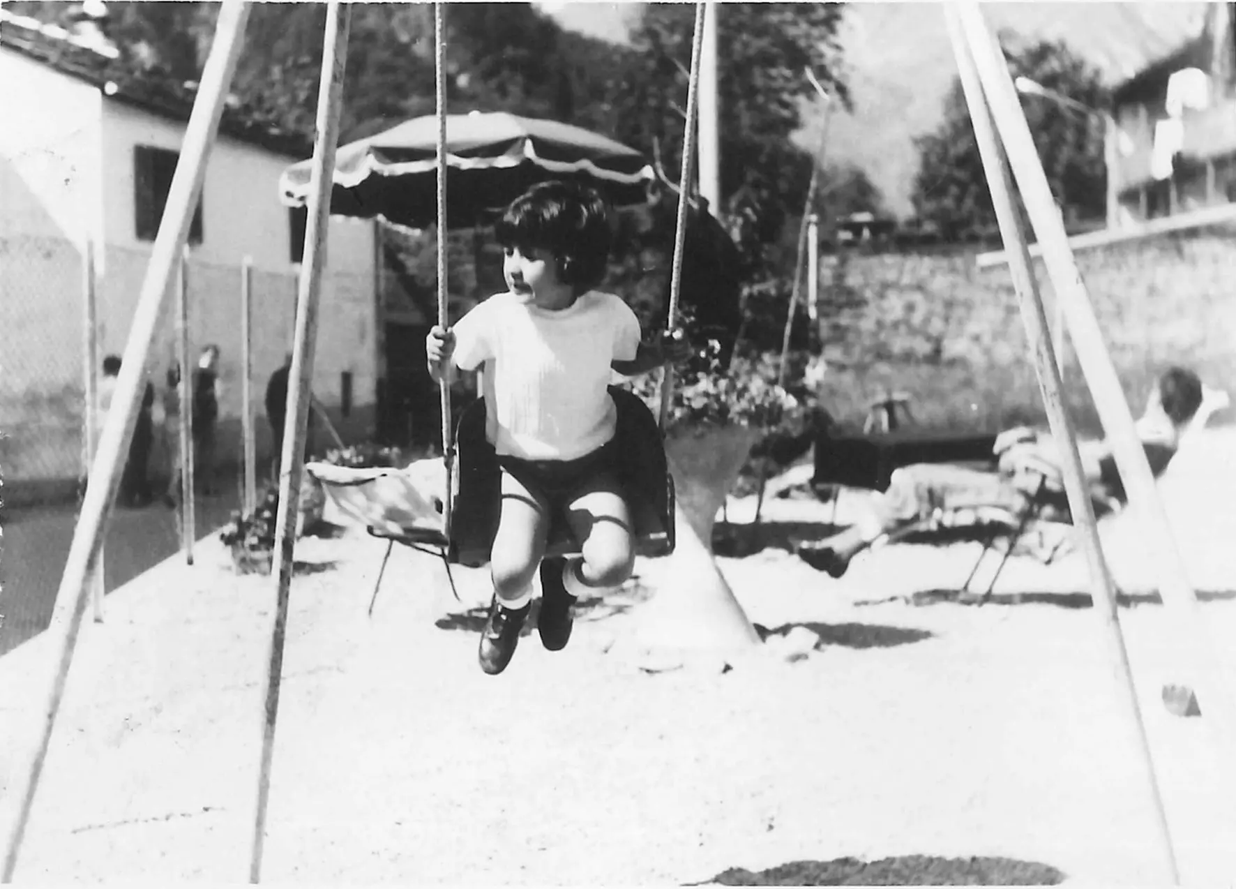 Maria Cristina bambina sull'altalena rossa (foto tratta dal libro)
